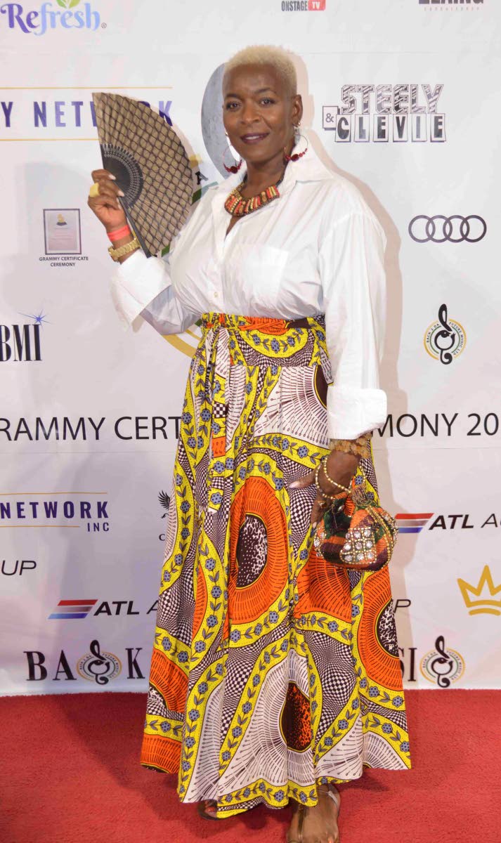 Magion Stephenson, deputy general manager of Grace Foods and Services, pairs a white button-down with a printed maxi and matching purse, keeping cool with a chic hand fan.
