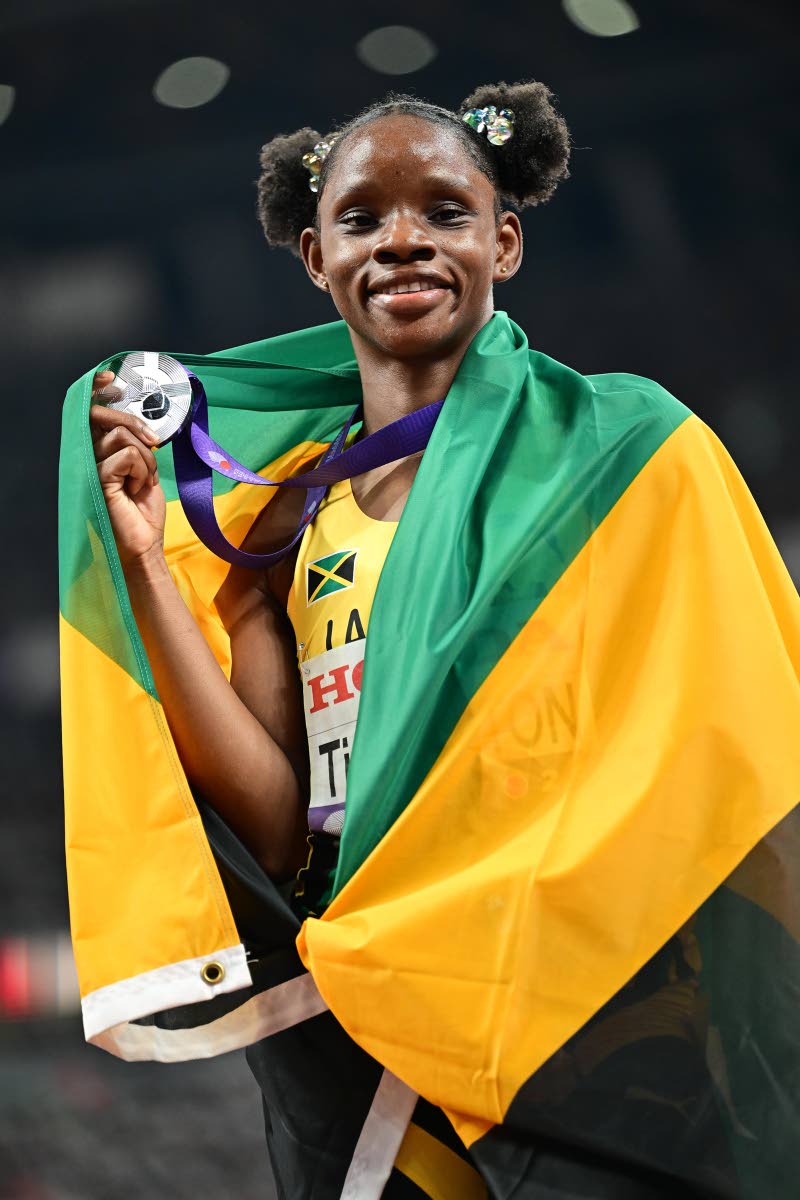 Left: Tina Clayton celebrates with her silver medal after placing second in the women’s 100 metres final at the 2025  World Athletics Championships in Tokyo, Japan, yesterday. 