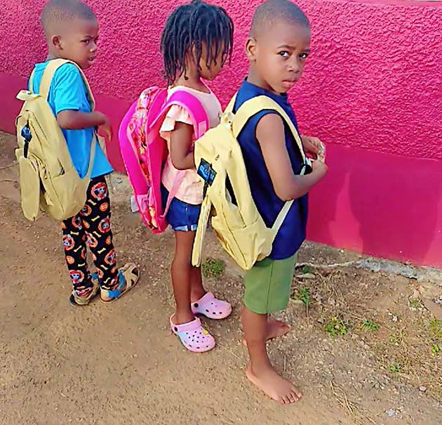 Kids show off backpacks they received at the treat.