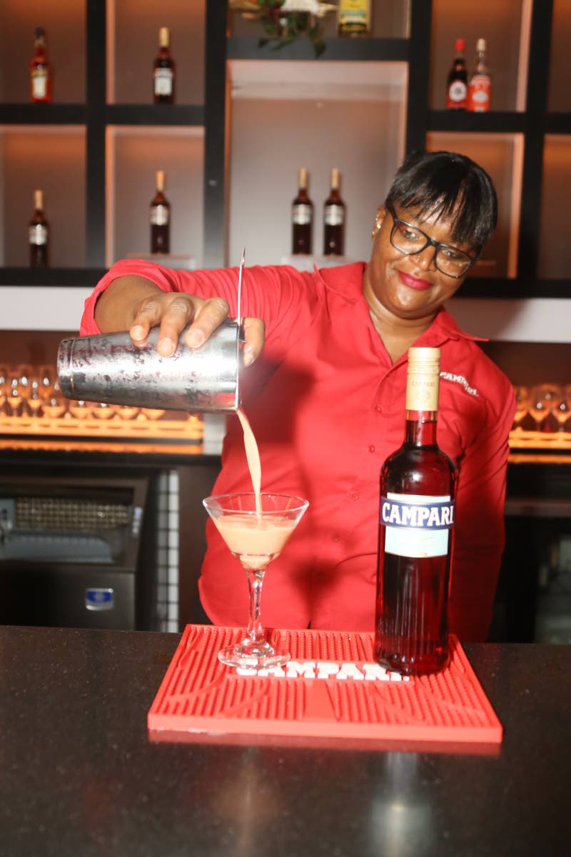 Mixologist Kareen Dixon serves one of Campari’s signature cocktails, Pink Passion, to a specially invited guest, alongside the brand’s newly sleek bottle design.