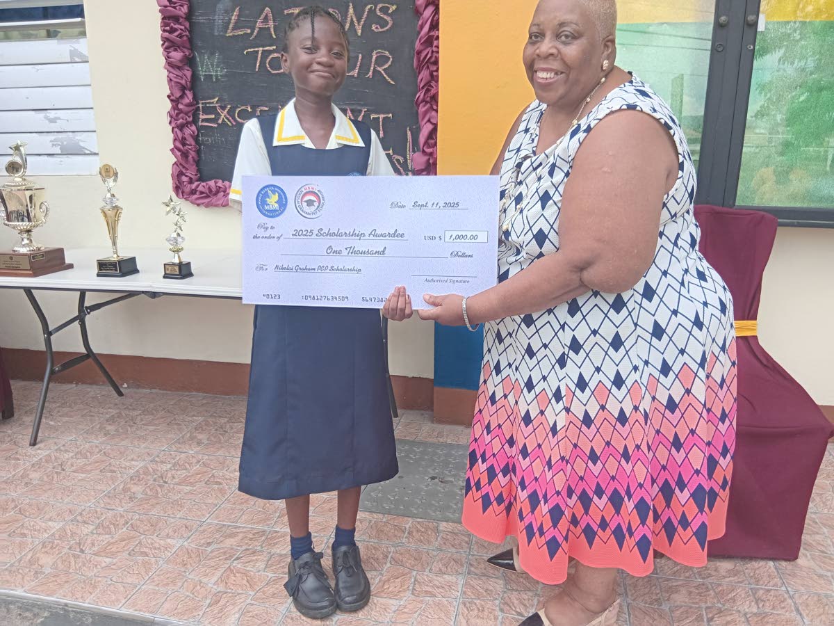 Pastor Marcia Wright  of the Marie Berbick Ministries presents a cheque to Shanice Colquhoun, winner of the Nicholai Graham Scholarship.
