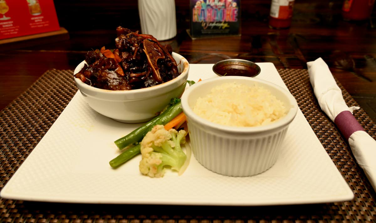 Oxtail served with white rice and vegetables.