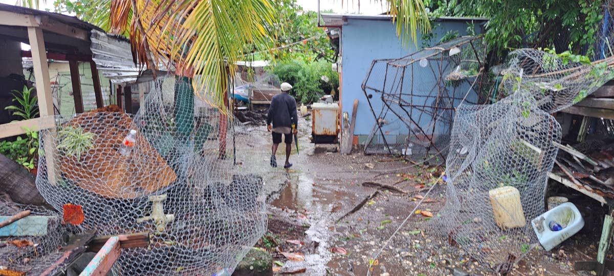 A fisherman assesses the fishing village in Portland on Tuesday during the passage of Hurricane Melissa.