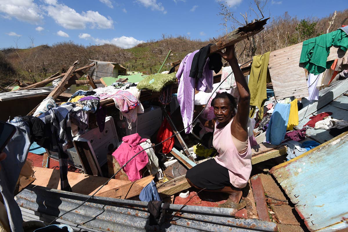 Sixty year old Juliet Clarke of Ipswich, St. Elizabeth, sits atop the rubble of her three bedrood board house after it collapsed during the passage of Hurricane Melissa.