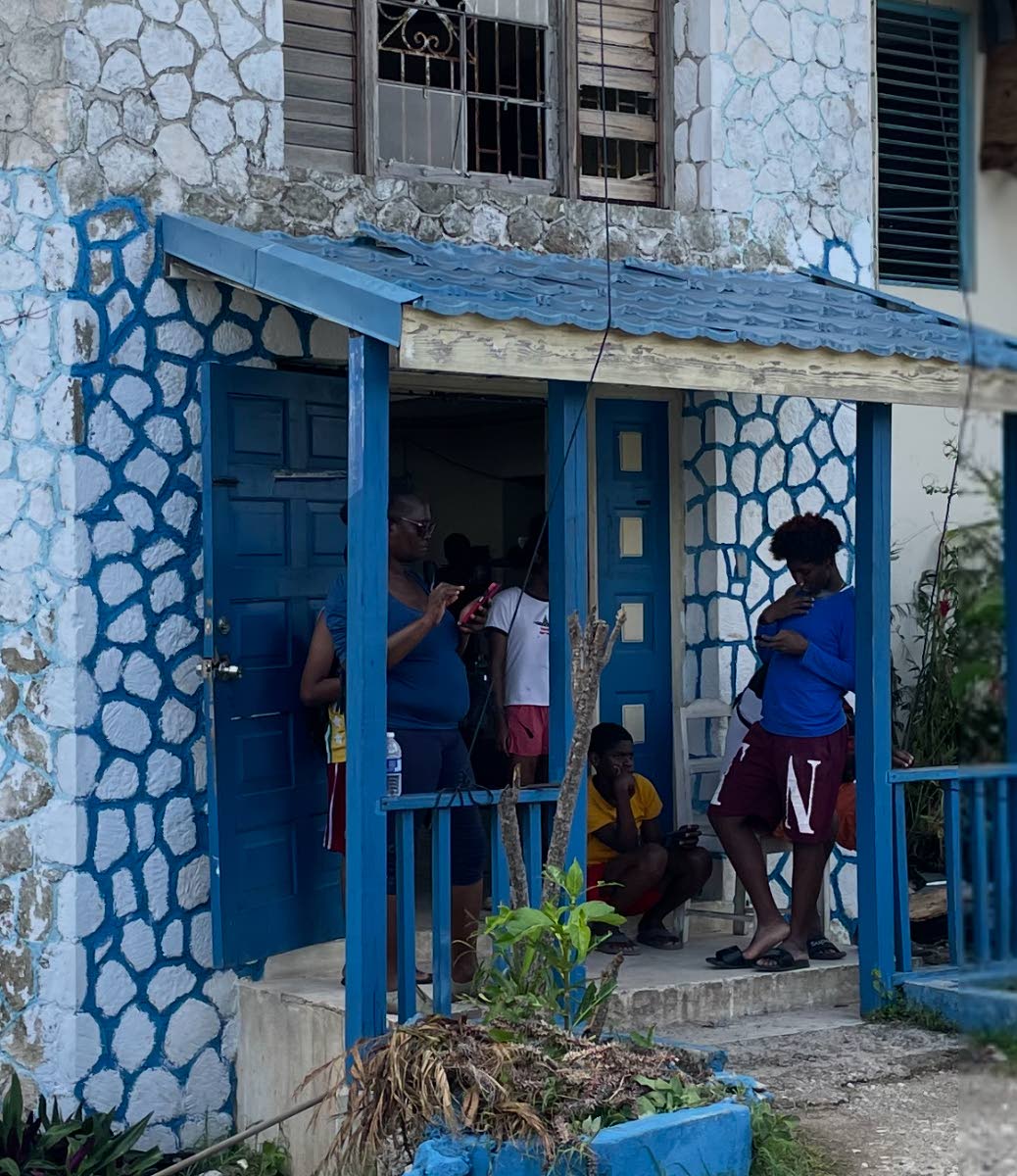 Residents making calls at the entrance to the Montego Hills Police Station.