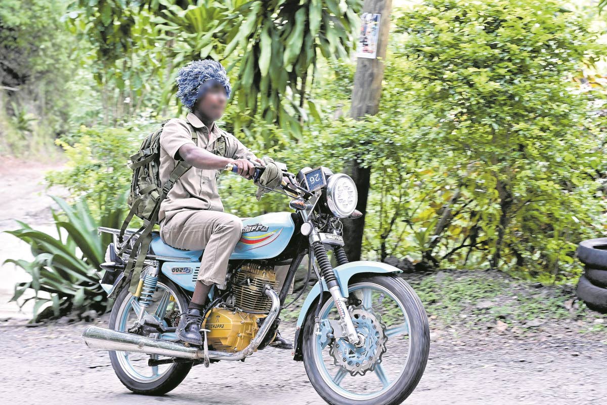 A sudent of Mavis Bank High School in St Andrew journeys home on his motorbike after school last week.
