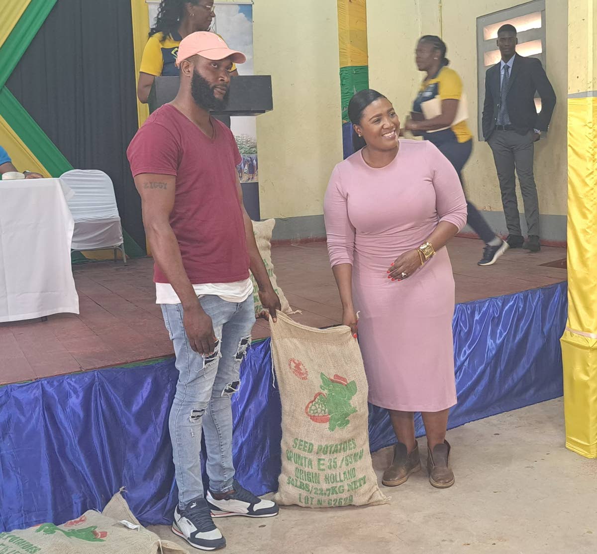 Kerensia Morrison, member of parliament for St Catherine North Eastern, handd a bag of Irish potato seeds to Guys Hill vegetable farmer Alrick Gordon.