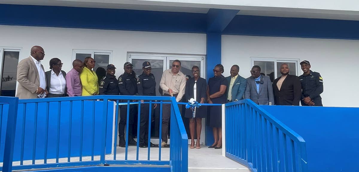 Prime Minister Dr Andrew Holness is flanked by several officials as he cuts the ribbon to open the new Little London Police Station in Westmoreland on Friday.
