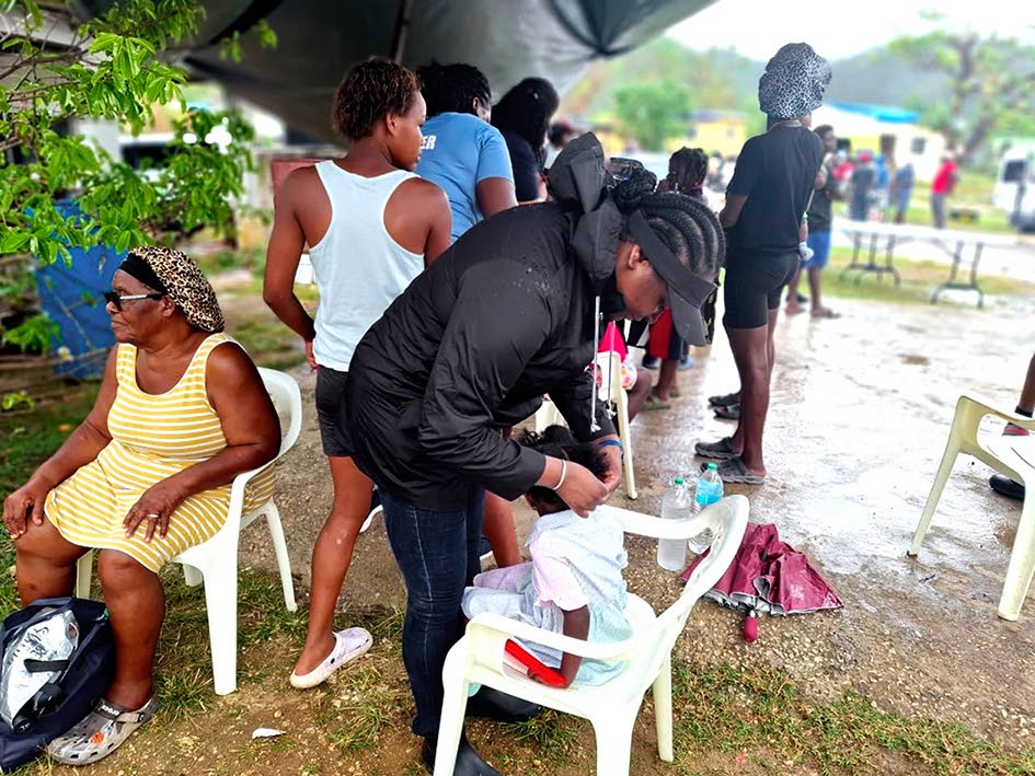 Tacine Lawson carefully braids a young girl’s hair with the belief that looking good makes you feel good, despite the circumstances after Hurricane Melissa.