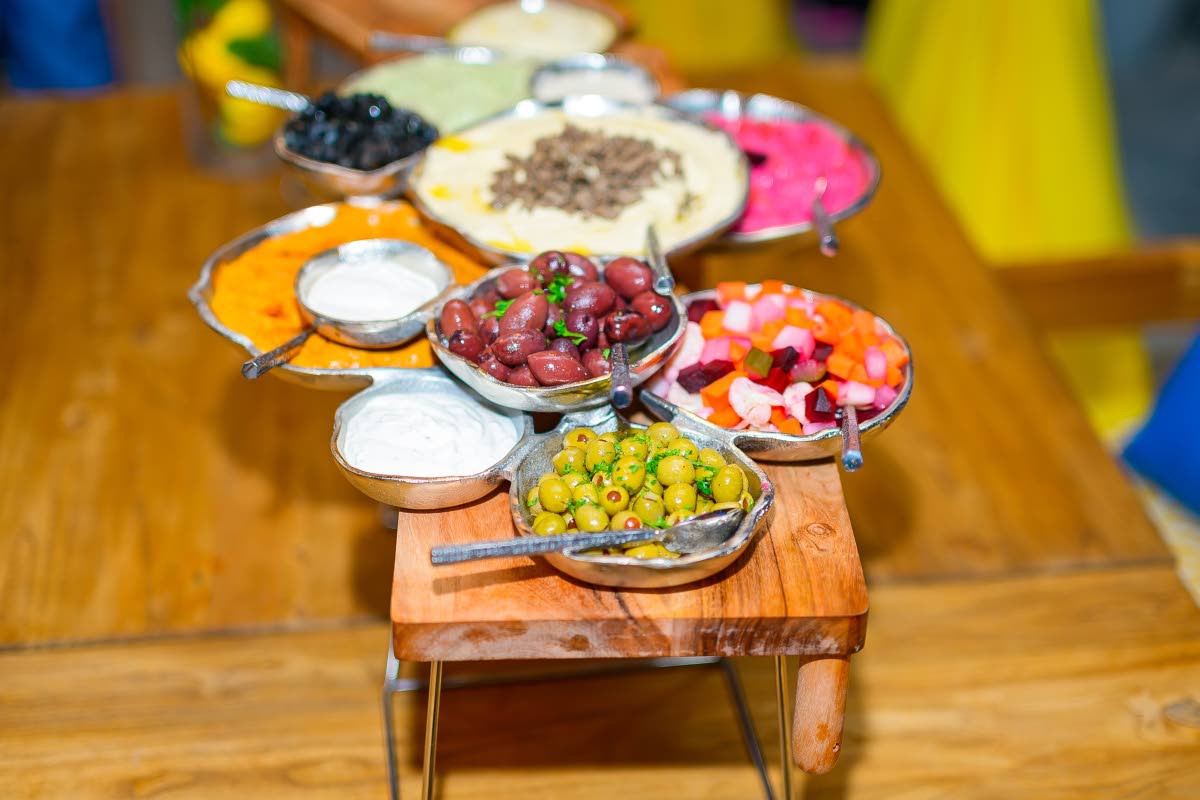 The colourful hummus bar at Mezza Luna’s grand opening, featuring a quartet of flavours, served alongside an array of olives, dips, and pickled vegetables for the perfect Mediterranean start.
