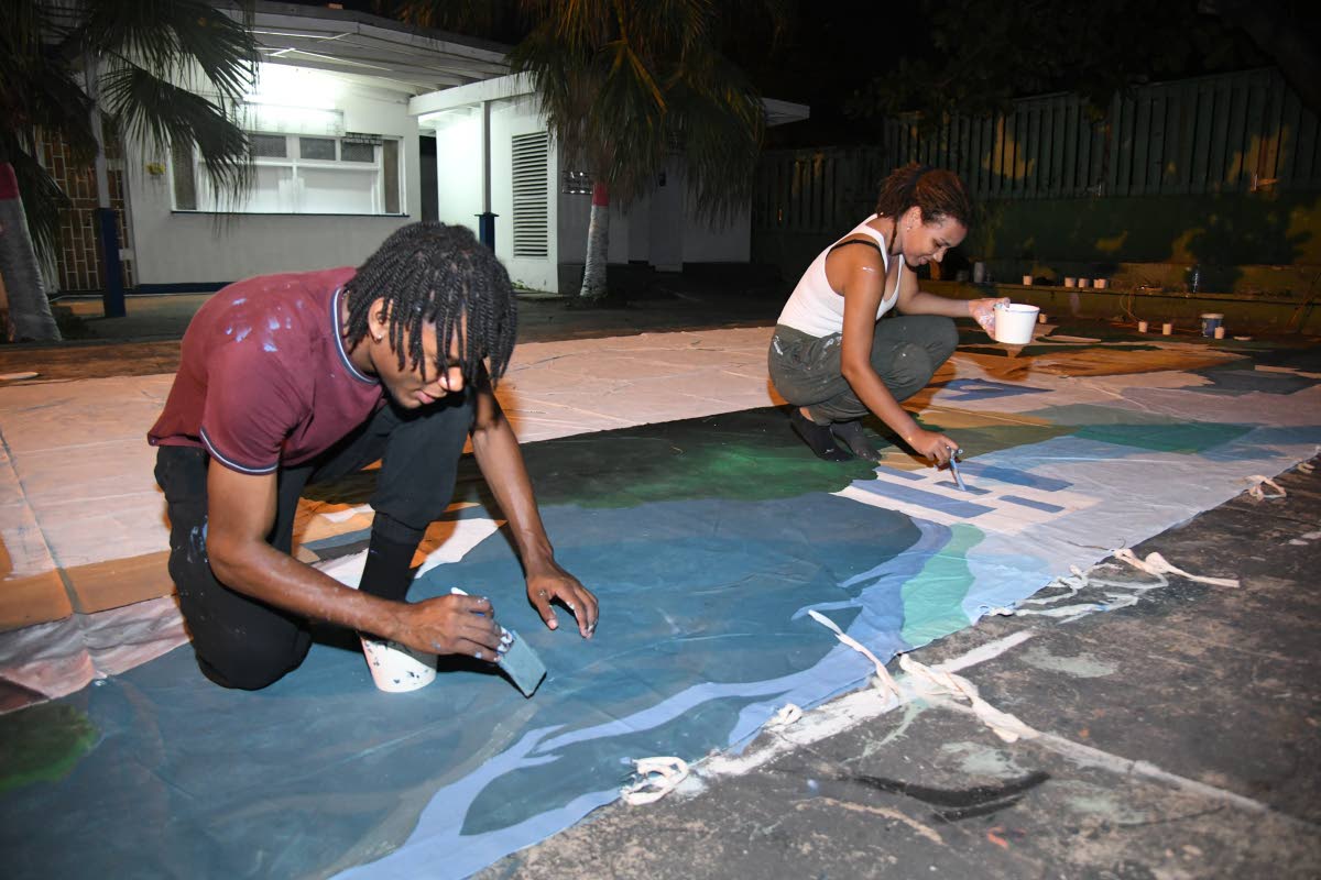 D’jaé Russell (left) and Eliana Mitchell paint the banner for ‘Big Yaad Vibes’ as they prepare for its Boxing Day debut.