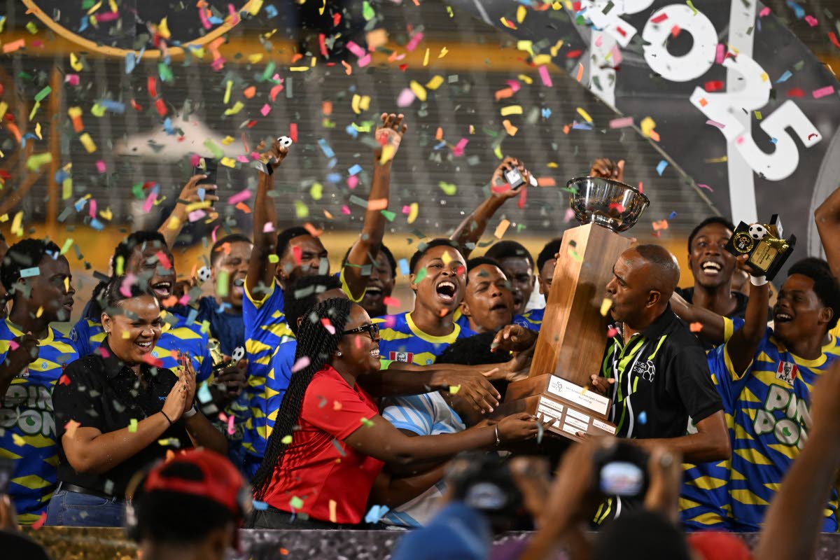 
St Elizabeth Technical High School players celebrate with the daCosta Cup trophy after an 8-7 penalty shootout victory over Glenmuir High School at the National Stadium last night. The game ended 0-0 in regulation time.