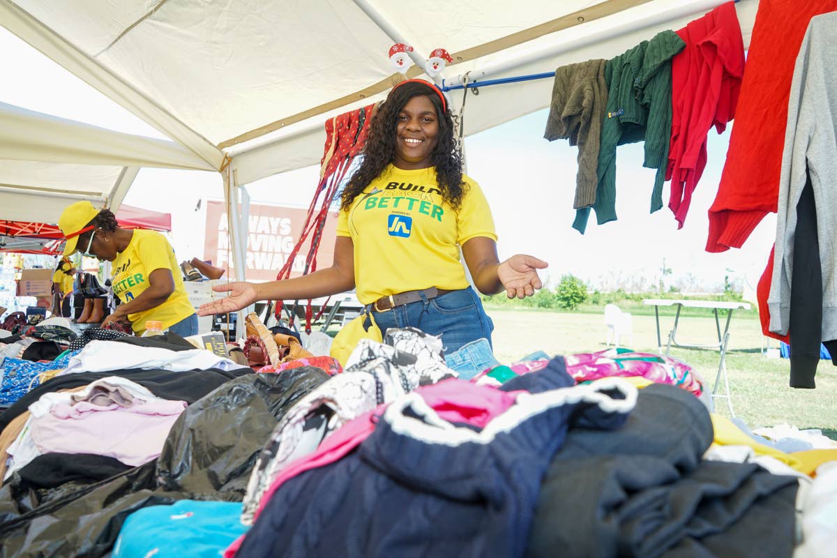 A JN Foundation volunteer shows off some of the items inside the thrift shop established on the football field of the William Knibb Memorial High School last Sunday. The shop was one of the highlights of an event organised and hosted by FYI Consultancy Gro