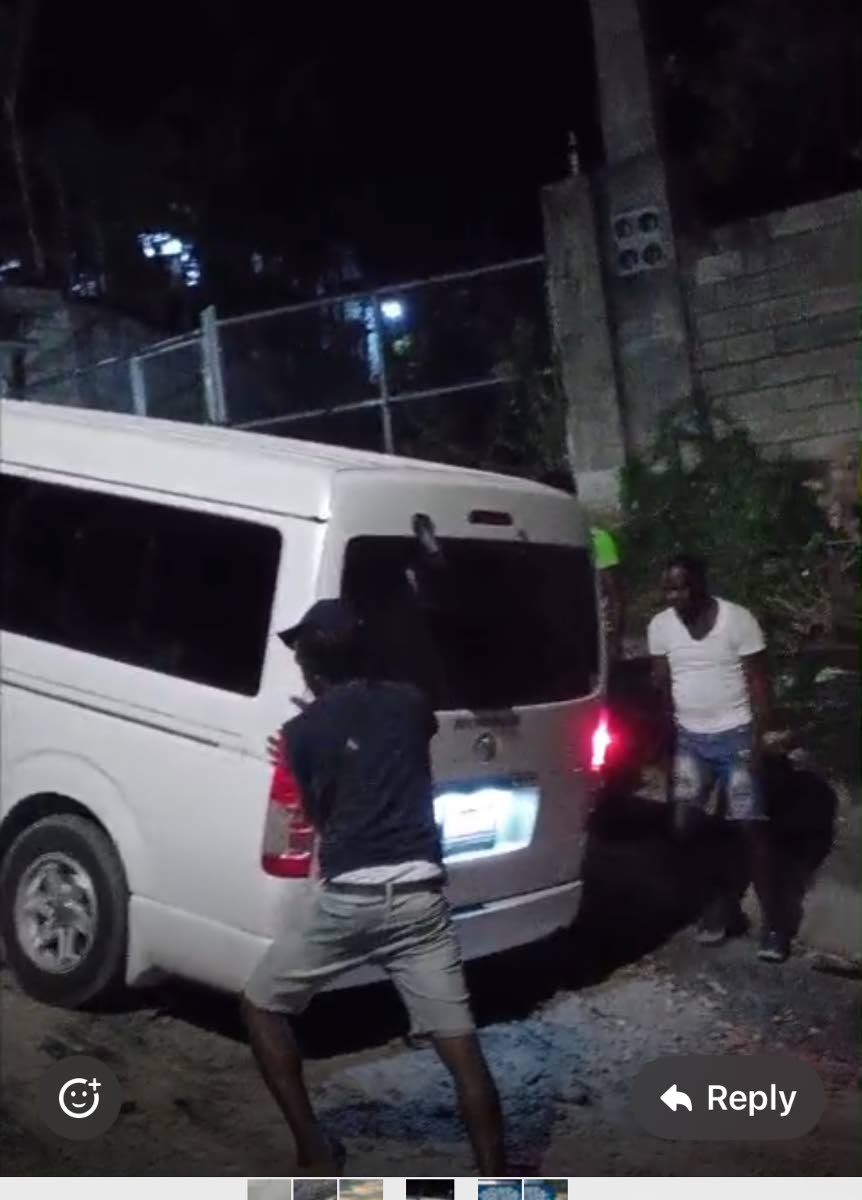 Residents assisting a motorist who got stuck in the mud going up the hill into Moy Hall.