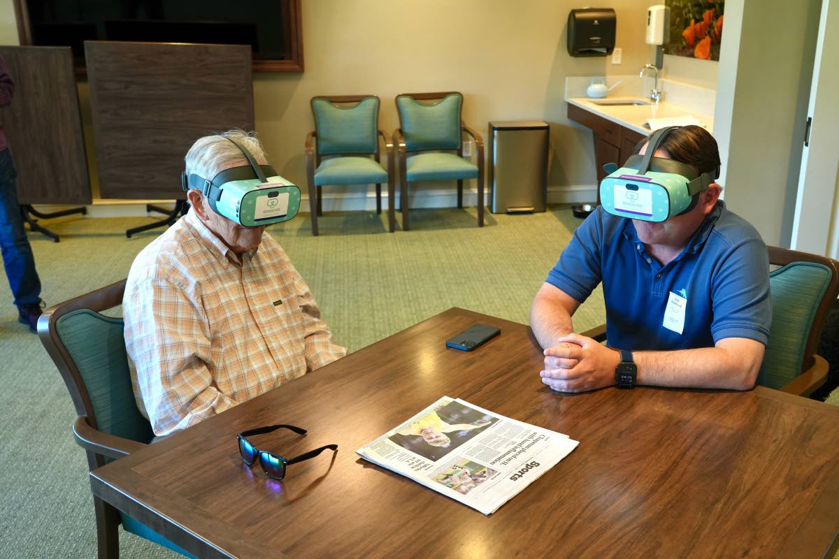 Jim Holtshouse and his son, Mike Holtshouse, watch video through Rendever virtual-reality headsets at the Forum at Rancho San Antonio retirement community in Cupertino, California. (AP Photo)