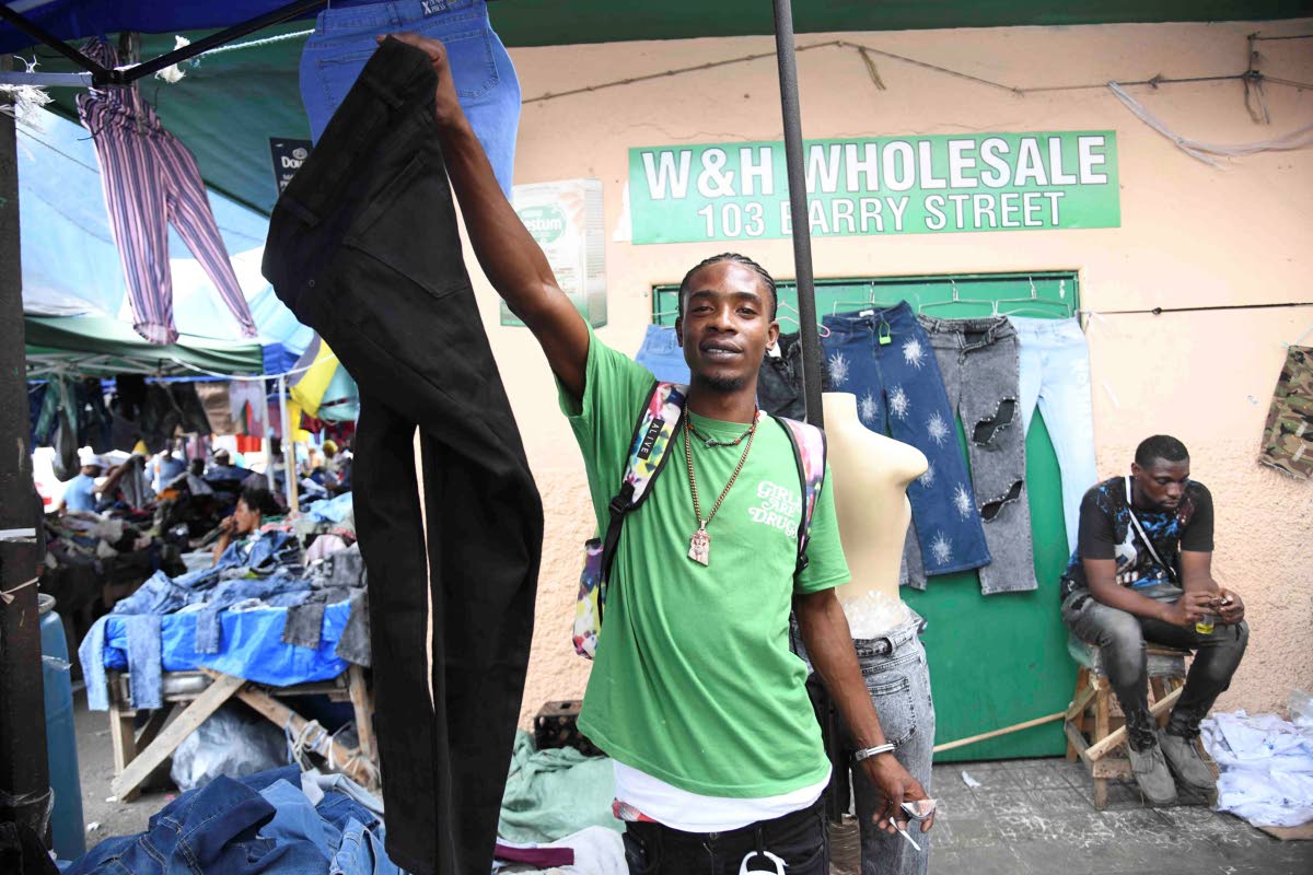 Mickoy Blake tried to get a sale at his stall on Orange street in downtown Kingston on Monday.