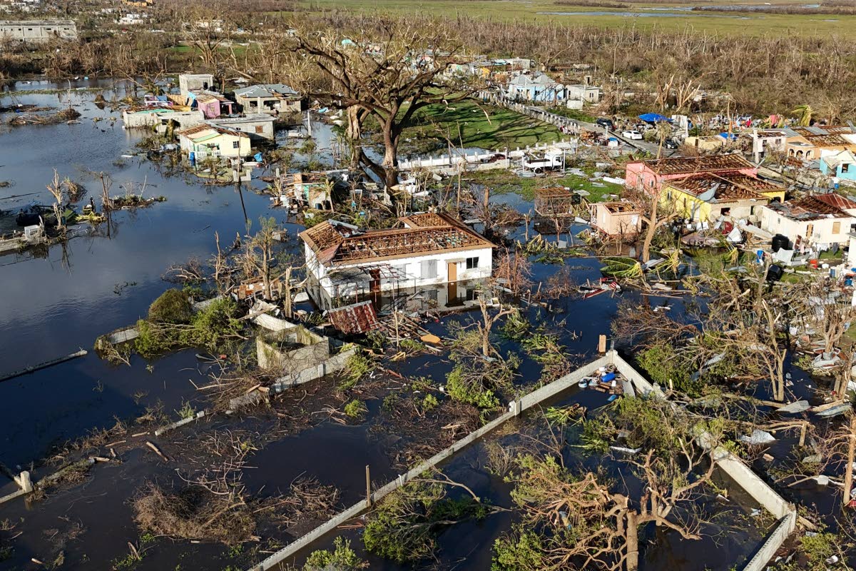 Debris surrounds damaged homes along the Black River, Jamaica, on October 30, 2025, in the aftermath of Hurricane Melissa.