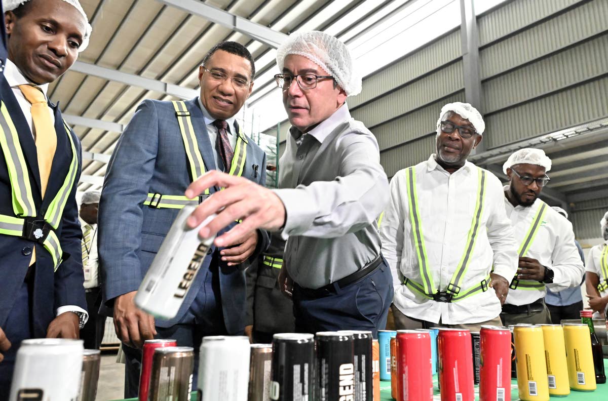 Andrew Mahfood (centre), CEO of Wisynco Group, displays one of the company’s beverages to (from left) Alando Terrelonge, state minister in the Ministry of Foreign Affairs and Foreign Trade; Prime Minister Dr Andrew Holness; Leon Thomas, mayor of Portmore