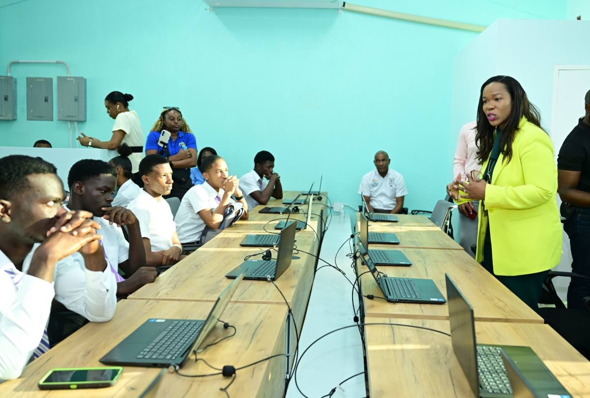 Permanent Secretary in the Ministry of Education, Skills, Youth and Information, Dr Kasan Troupe (right), engages with Bustamante High School students, during the handover of renovated and expanded information communications technology facilities at the in