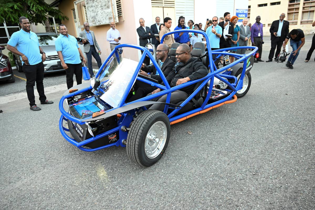 Professor Denzil Williams (right), principal and pro-vice-chancellor at The University of the West Indies (UWI) Mona, looks on from the passenger seat as Dr Louis-Ray Harris, senior  lecturer in the Department of Physics at The UWI, drives the EV-001 durin