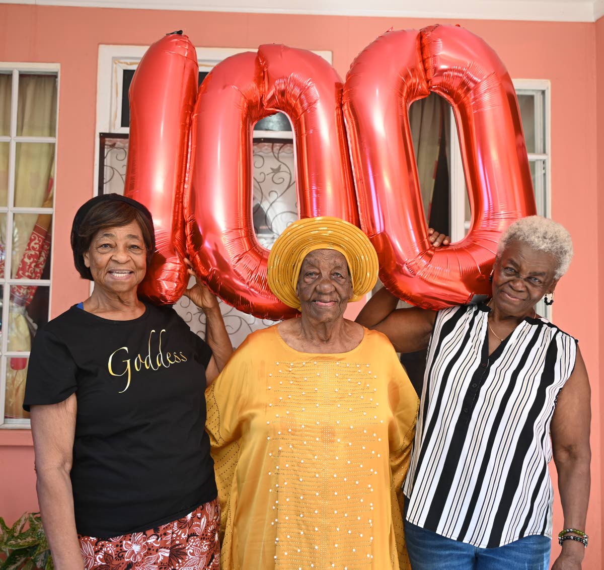Monica Shaw (left), the eldest child, and her sister Melcete Haase (right) celebrate with their mother, Ethlyn Clarke, as she marks her 100th birthday.