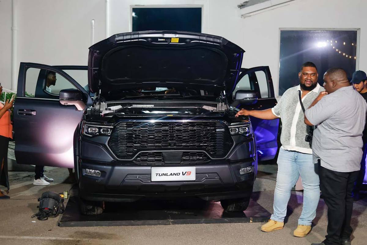Attendees examine the 2.0L Turbo Diesel engine of the Foton Tunland V9.