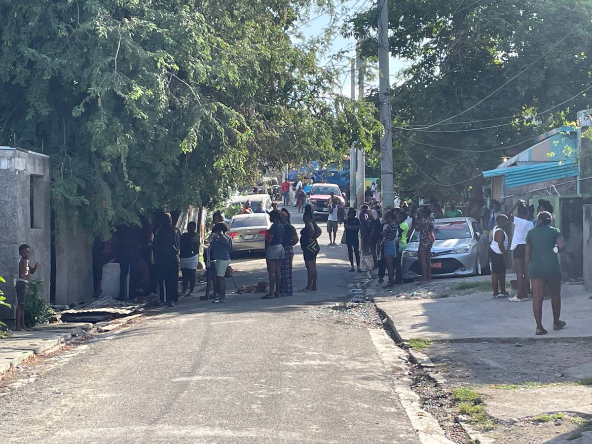 Photos by Andre Williams 
Residents and police personnel in Denham Town, Kingston on Saturday morning after a fatal gun attack at a home claimed the life of a toddler and left his brother and father wounded.