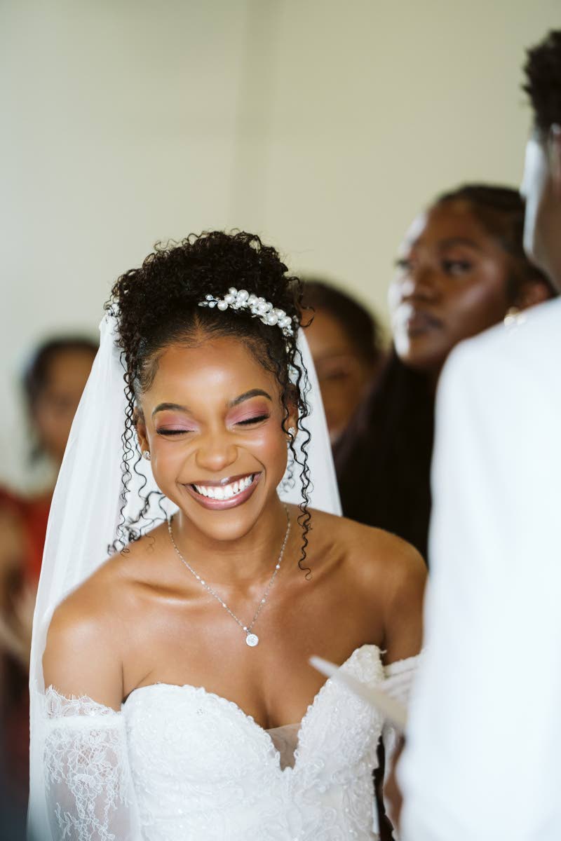 Mrs Thomas is captured in a candid moment, wearing a Frederique ivory beaded mermaid gown from Bliss Bridal Boutique.