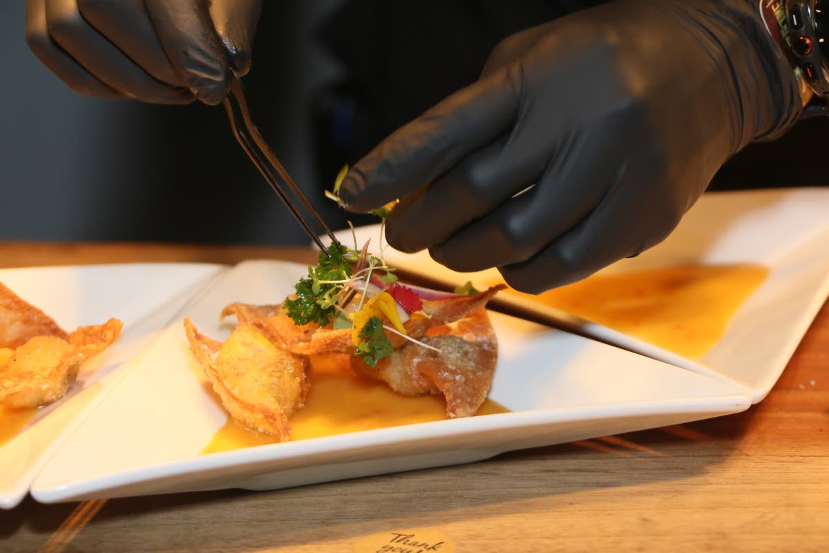 Chef Lumley puts the finishing touches on the ackee and salt fish wonton with sweet chilli mayo and mango chutney glaze.