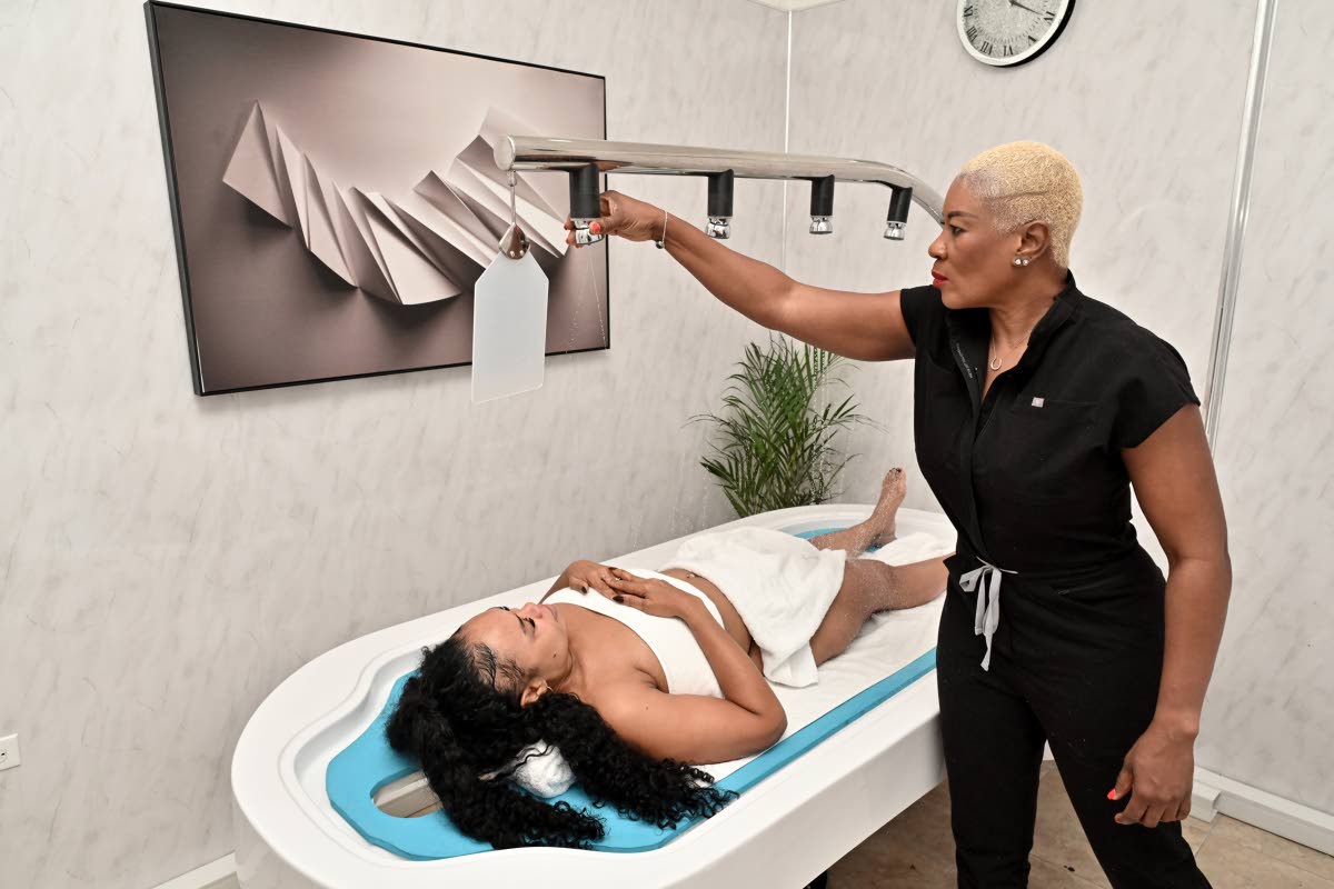 Andrea Johnson (right), makes preparations for a massage as model, Nicole Bolt, looks on. 