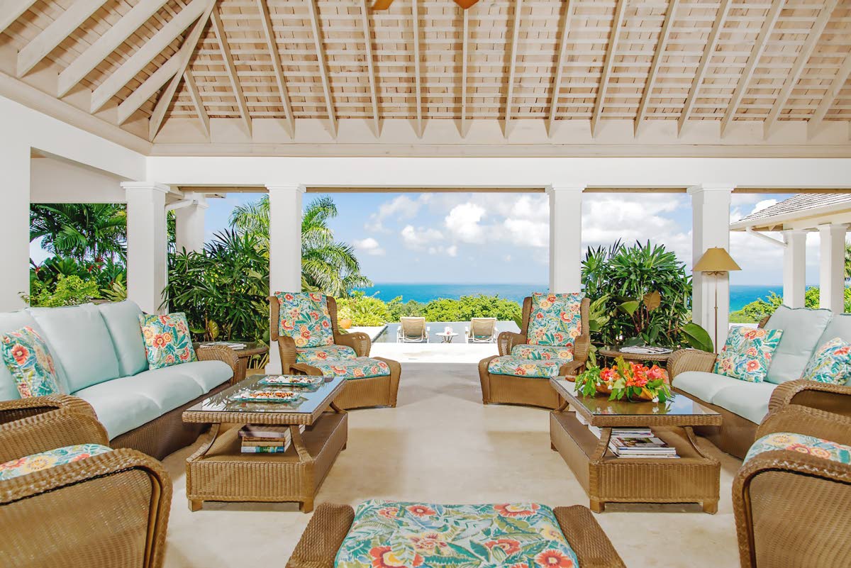Relax in the outdoor living room overlooking lush greens and the sea.