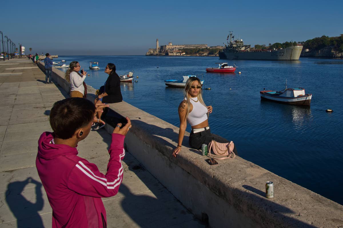 People take photos at Havana Bay as the Mexican Navy ship Isla Holbox, carrying aid according to the Mexican government, arrives in Cuba, Thursday, Feb. 12, 2026. 