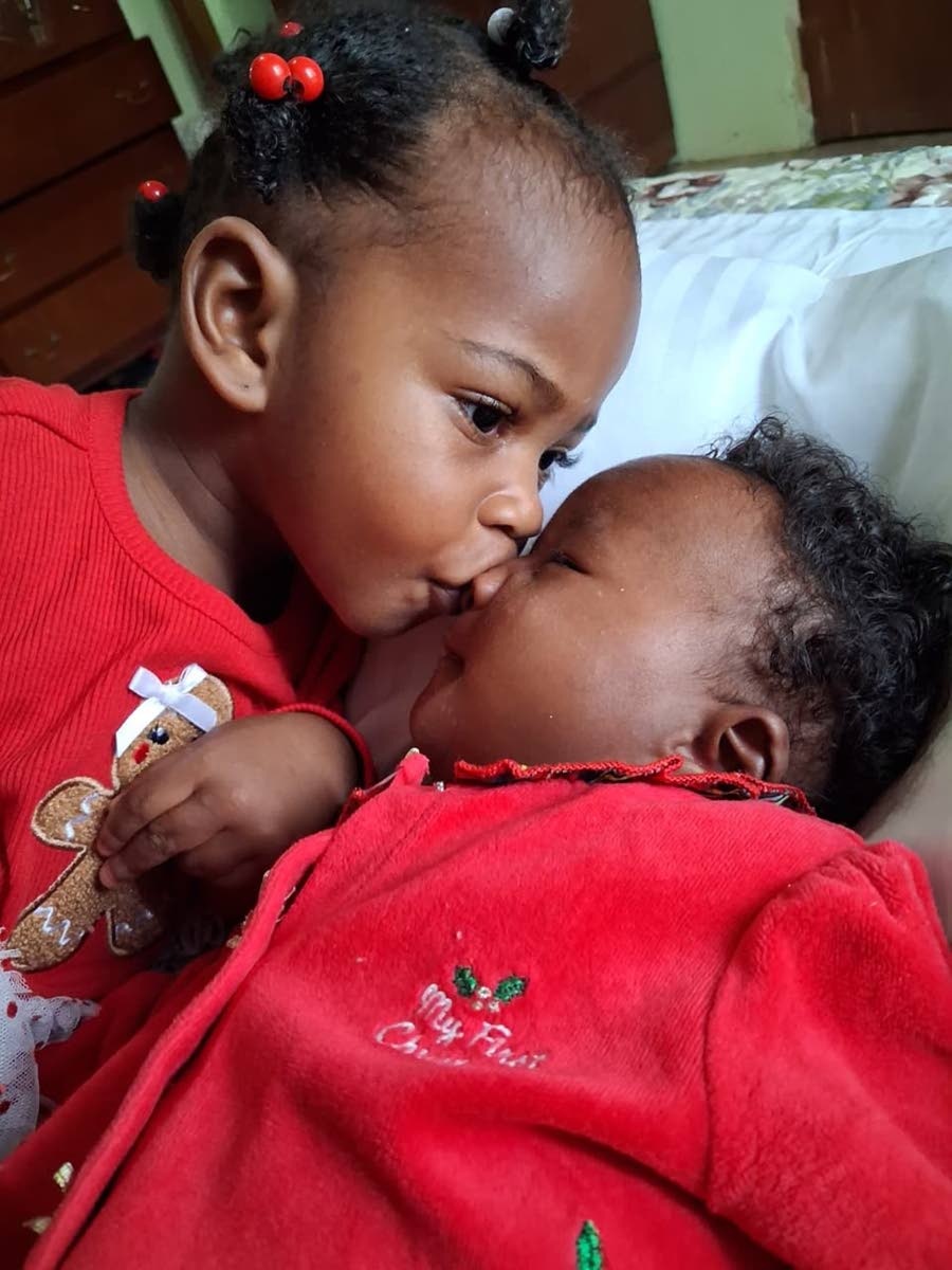 Big sister Arielle kisses ‘Boy’, her nickname for little sister Anna-Olivia.