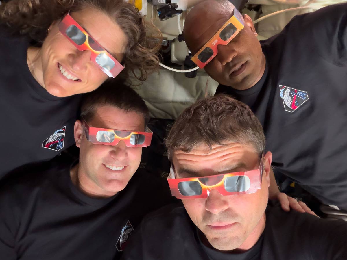 In this image provided by NASA, the Artemis II crew (counterclockwise, from top left), Mission Specialist Christina Koch, Mission Specialist Jeremy Hansen, Commander Reid Wiseman, and Pilot Victor Glover pose with eclipse viewers during a lunar flyby on Ap
