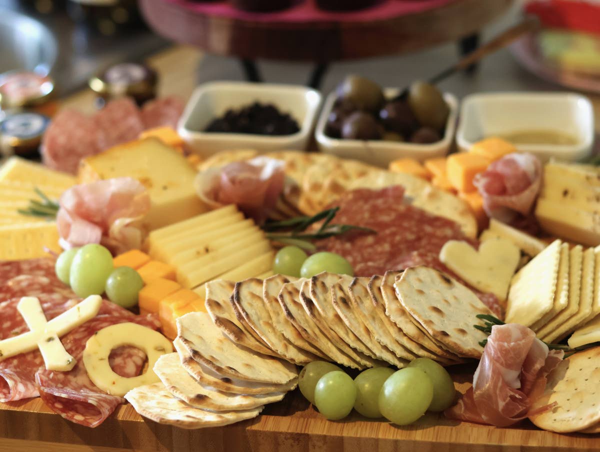 An arrangement of crackers, cheeses, meats, fruits and spreads is prepared for guests at a gathering of friends at an apartment in Flagstaff, Arizona.