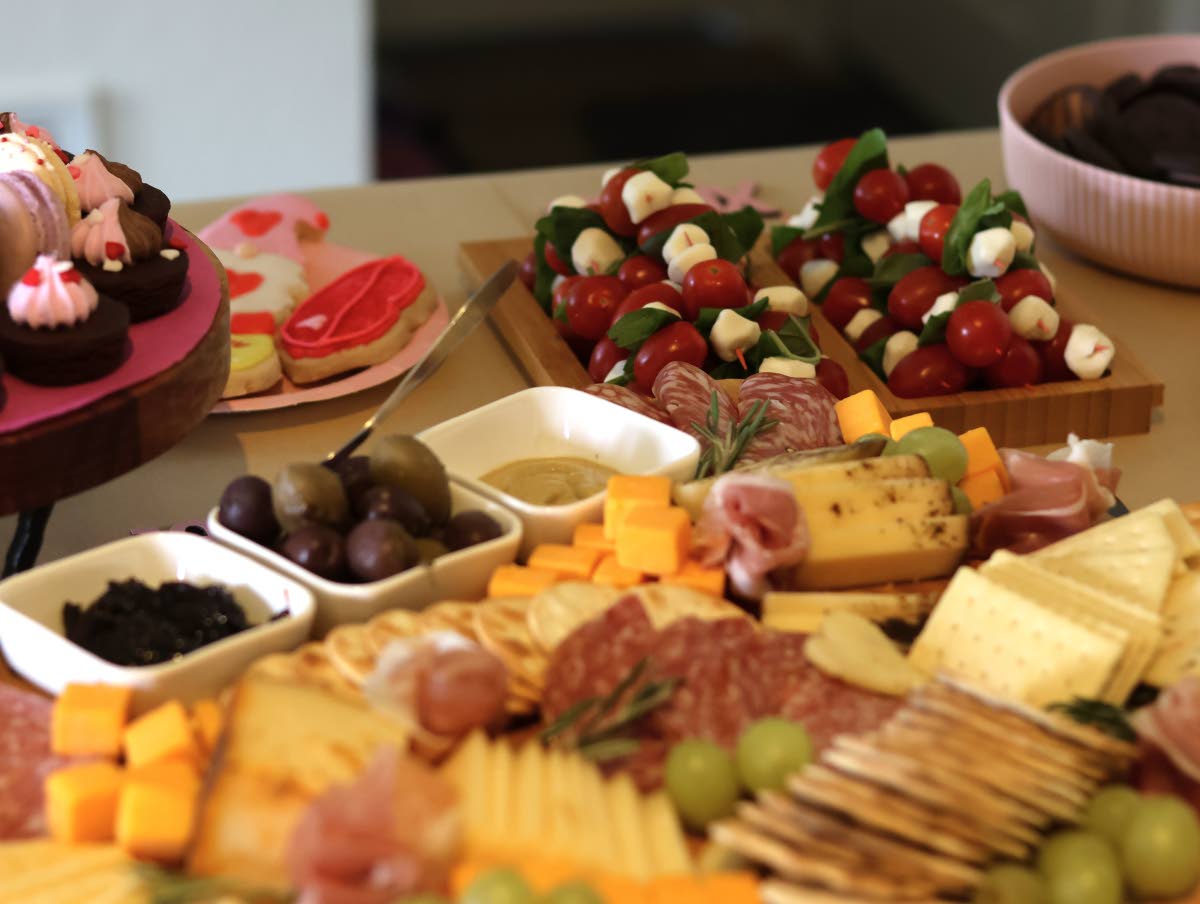 An arrangement of crackers, cheeses, meats, fruits and spreads