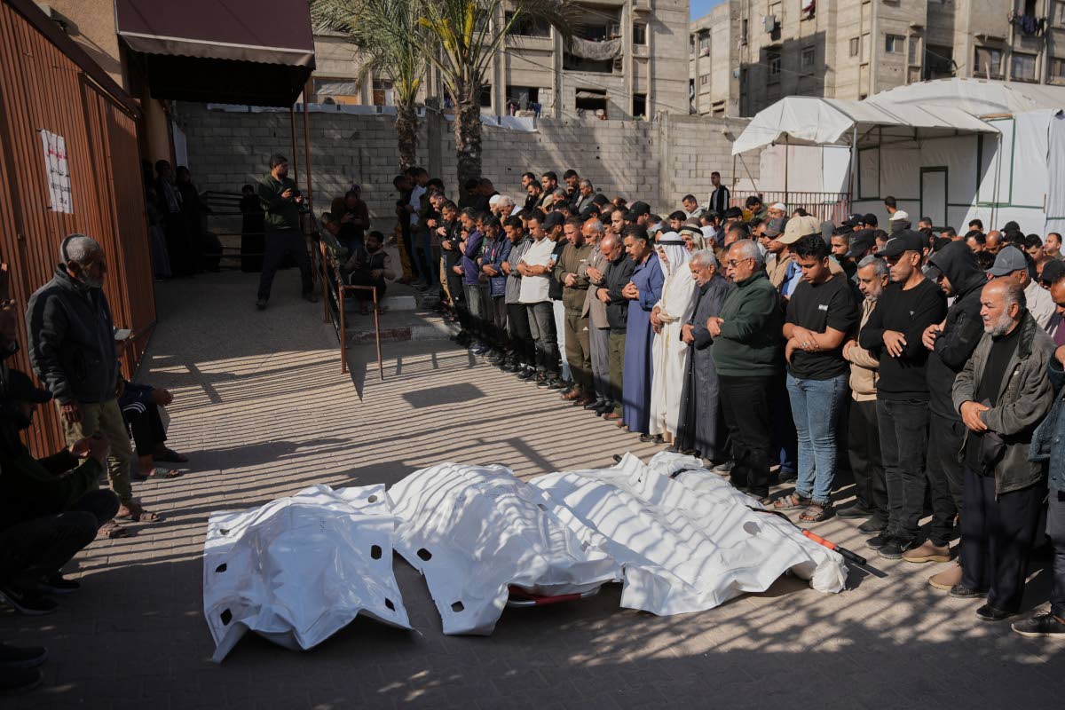 Palestinians pray beside the bodies of men killed in an Israeli strike, during their funeral at Nasser Hospital in Khan Younis, southern Gaza Strip, Tuesday, April 21, 2026.
