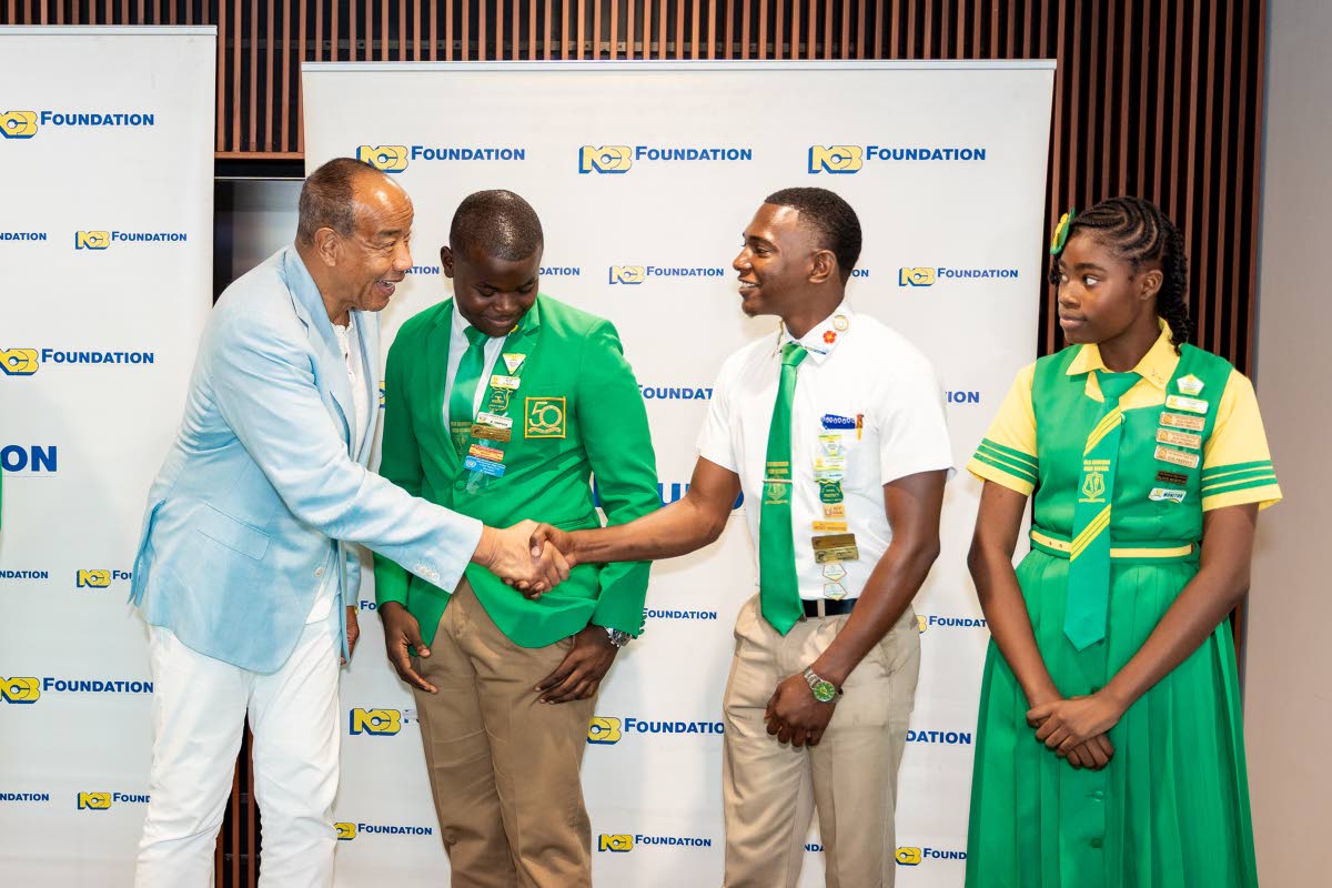 Michael Lee-Chin (left), chairman, NCB Financial Group Limited, greets Head Boy Richard Simpson(second left); Jabari Mannings, second deputy head boy; and Layla Price, sub prefect (all members of the school leadership of Old Harbour High) during a recent M