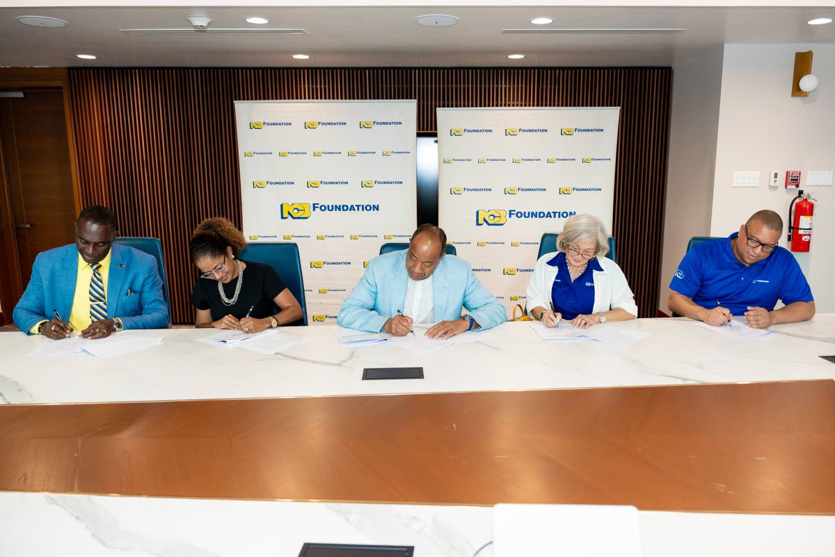 The landmark MOU signed, signaling the intention to begin a targeted collaboration. Seated at the signing table are (from left) Lynton Weir, principal of Old Harbour High School; Sheree Martin,  interim CEO of National Commercial Bank Jamaica Limited; Mich