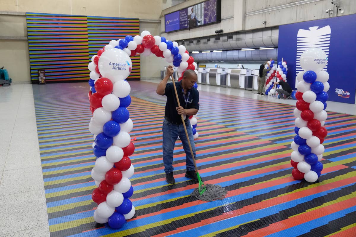 A worker cleans the check-in area ahead of the arrival of a US commercial flight at Simon Bolivar International Airport in Maiquetia, Venezuela, Thursday, April 30, 2026, as direct air service between the United States and Venezuela resumes after seven yea