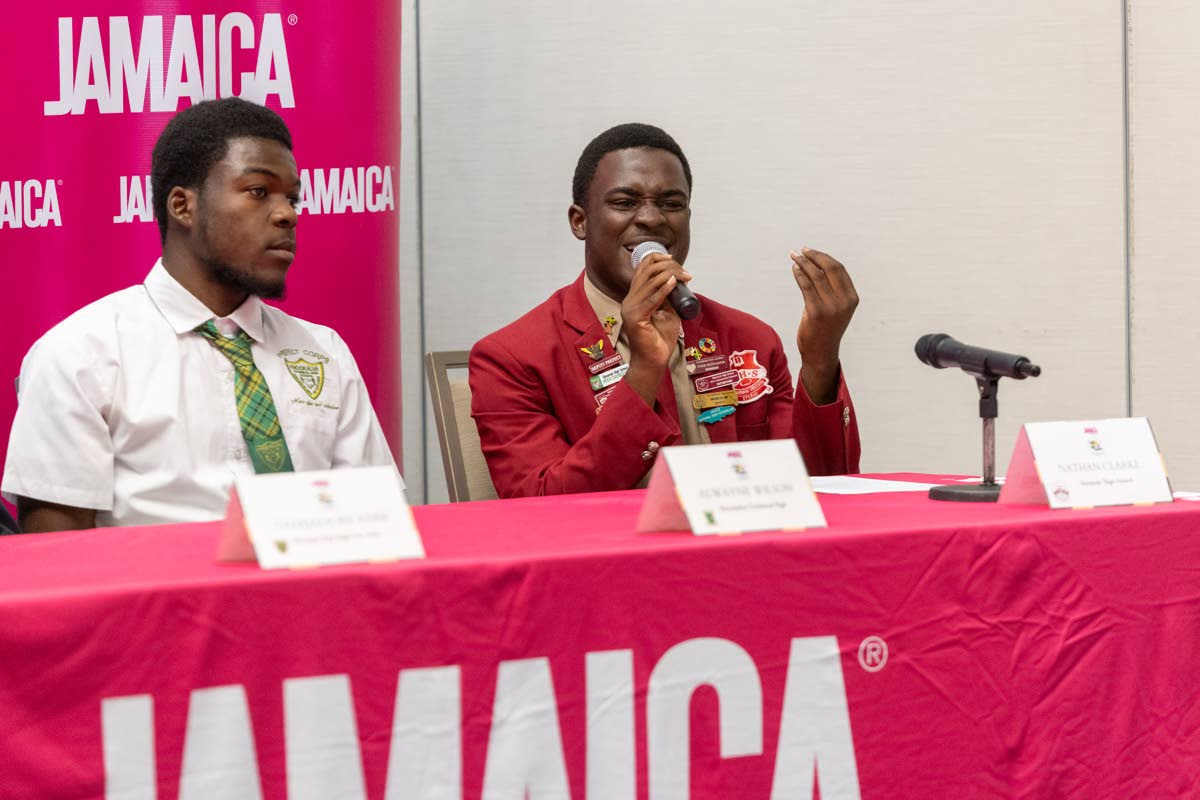 Nathan Clarke (right) of Glenmuir High delivers his presentation to top round one of the 2026 Junior Minister of Tourism Public Speaking Competition, held at AC Hotel Kingston on July 10. Looking on is Alwayne Wilson of Knockalva Technical High School.