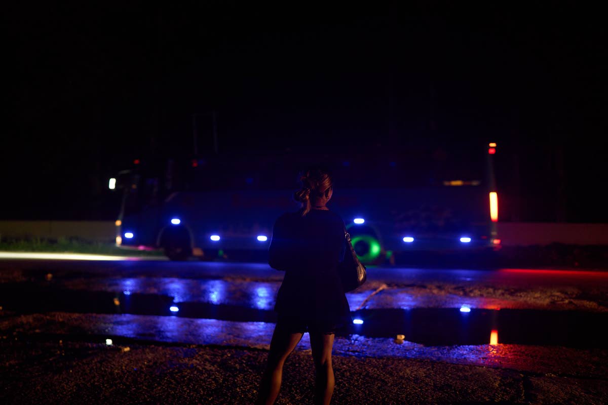 A transgender sex worker stands next to a busy highway waiting for clients to approach her in Hetauda, Nepal.