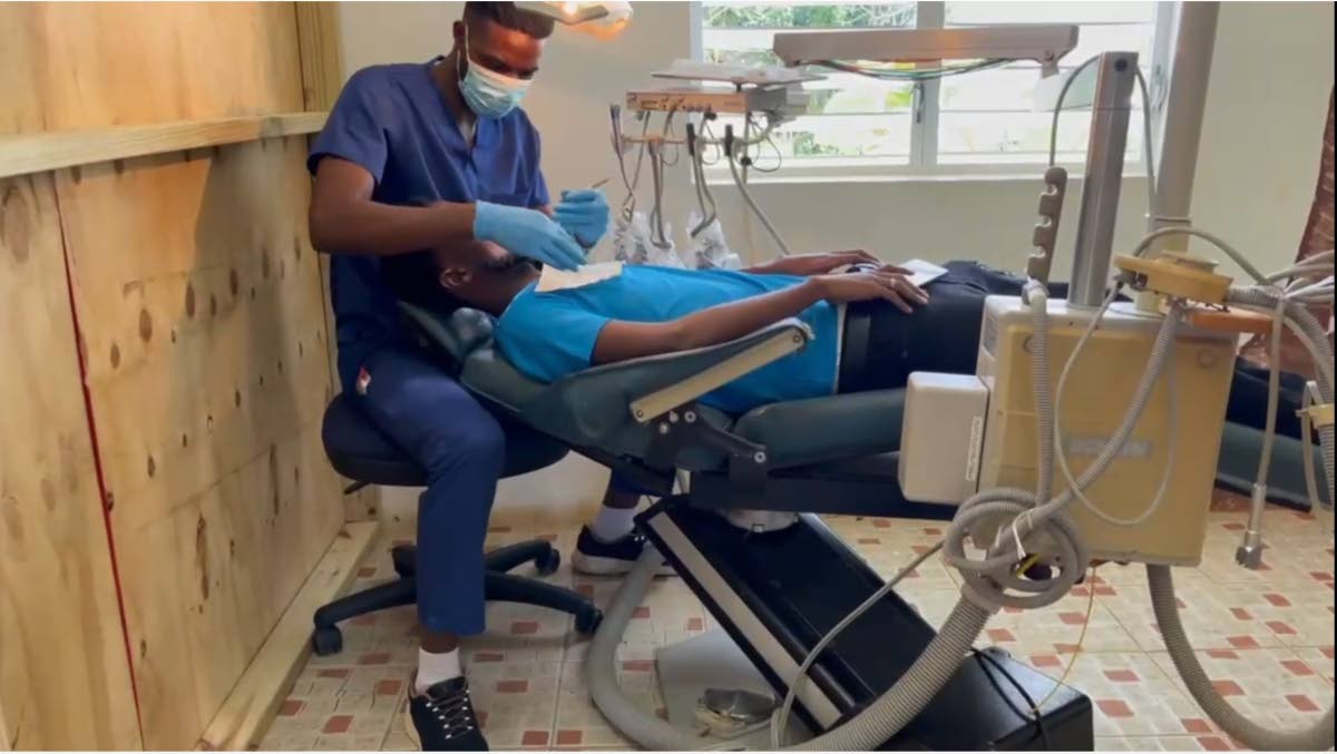 Dental hygienist Phillip Williams treats a patient during a recent two-day medical and dental mission in Good Hope, St Elizabeth.