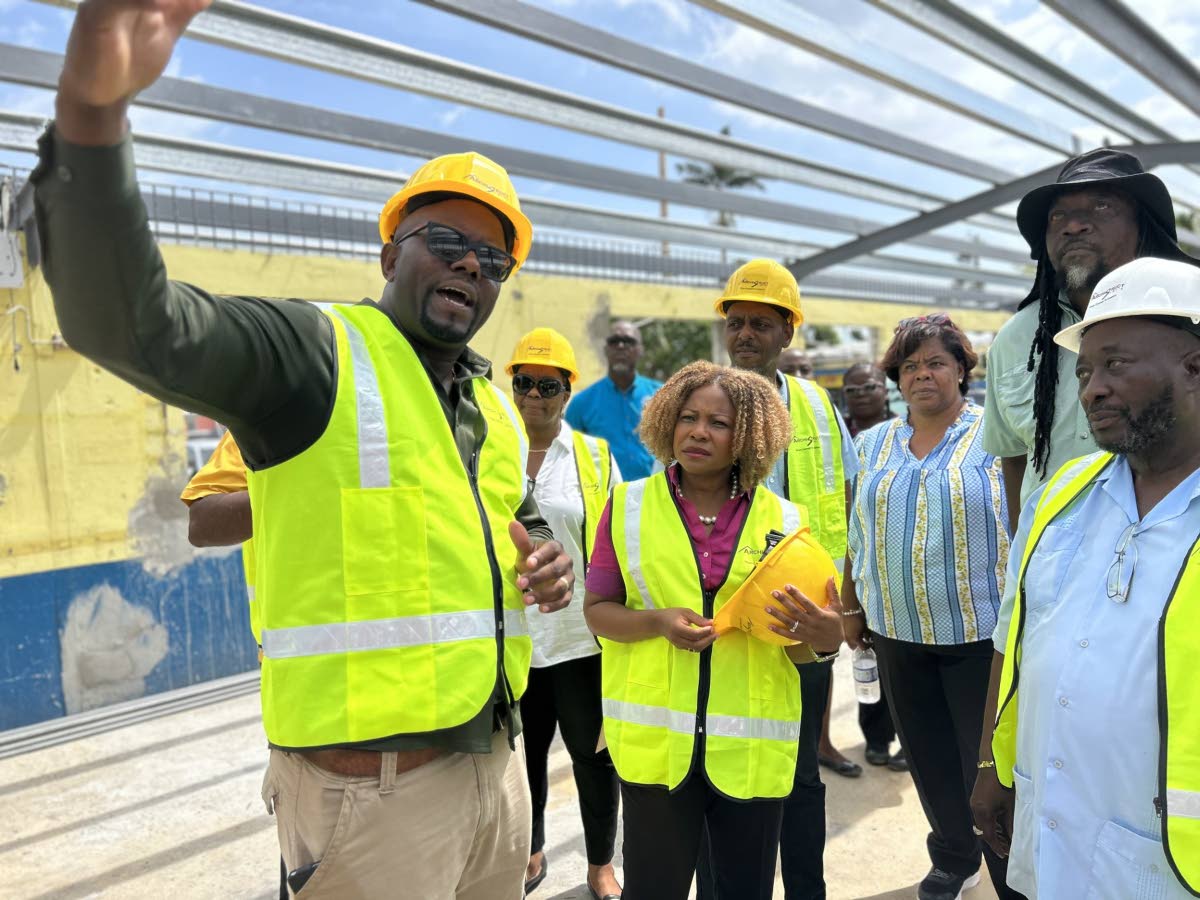 Education Minister Dr Dana Morris Dixon consults with a contractor while inspecting ongoing reconstruction work at Petersfield Primary School in Westmoreland on Tuesday.