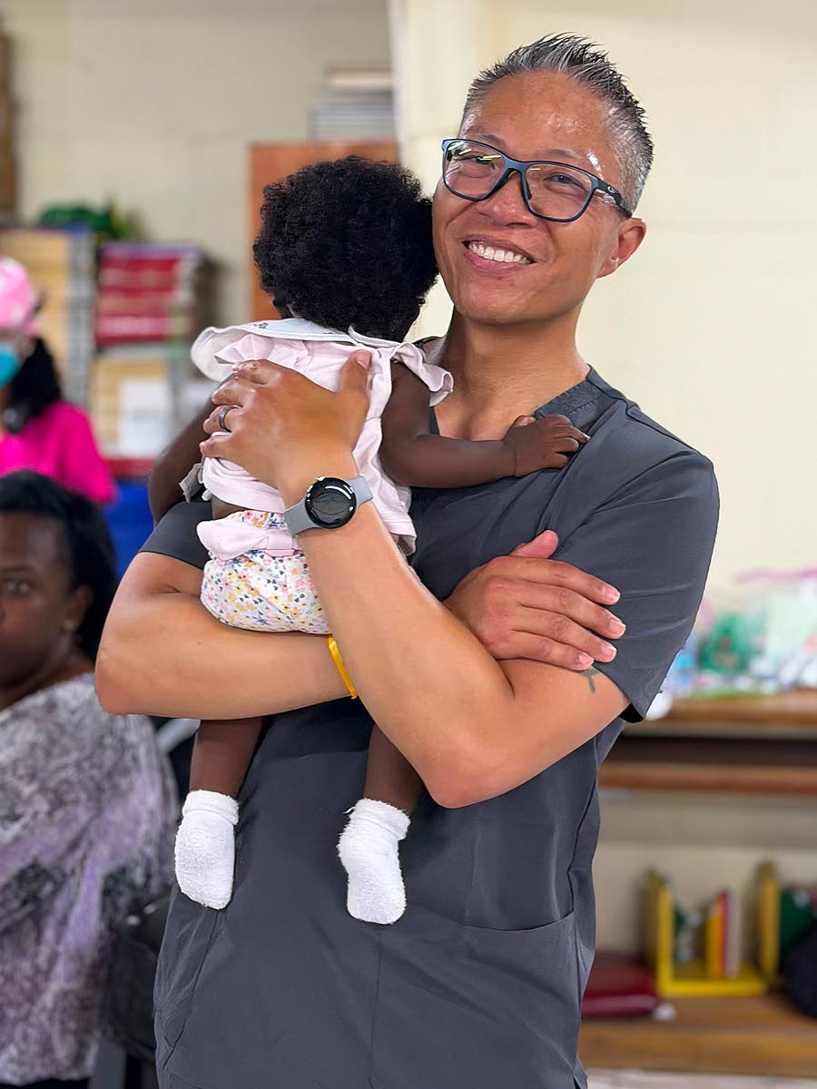 A medical professional comforts a crying infant during Zion Care International’s recent medical mission in Jamaica.