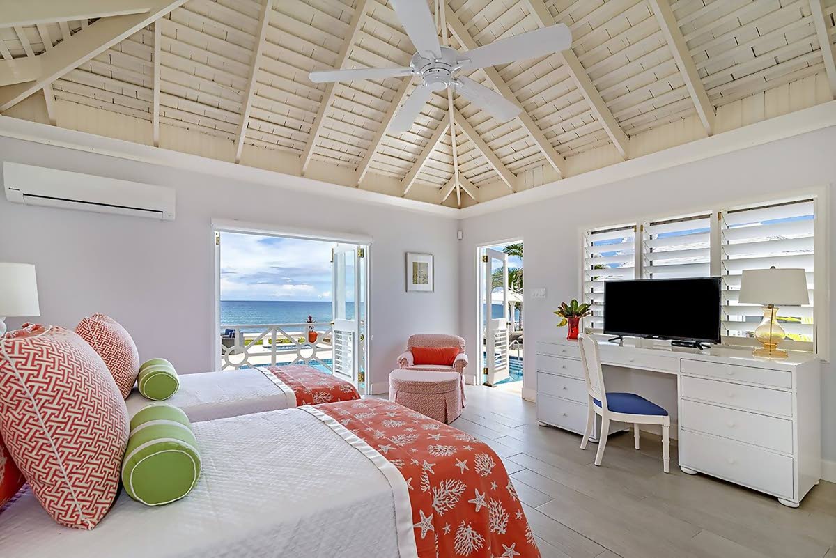 A bedroom opening to the pool and sea through two separate doorways. 