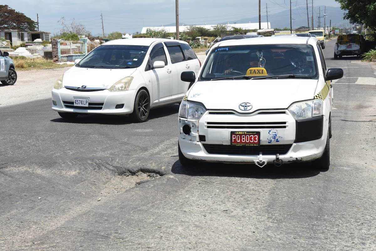 Motorists carefully avoid this pothole and depression along Spanish Town Road in the vicinity of Collie Smith Drive in St Andrew.