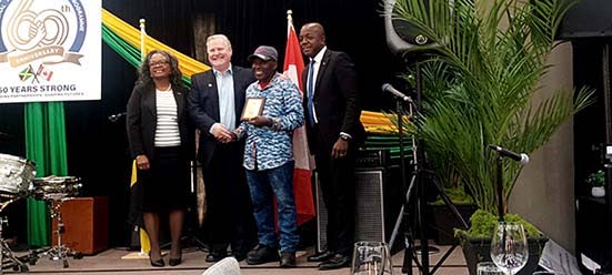 Althea Riley, Chief Liaison Officer of the Jamaican Liaison Service; Peter Bordignon, Deputy Mayor of The Blue Mountains; farmworker Stephen Salmon; and Pearnel Charles Jr., Minister of Labour and Social Security, at the Seasonal Agricultural Worker Progra
