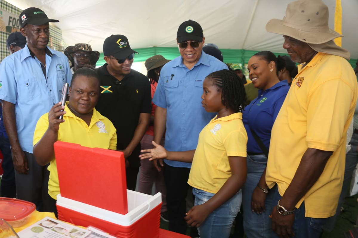 Ten-year-old Taylor Robinson (foreground, right) and her mother, Marshanna Furze, showcase their RYEEP agro-business, specialising in goat’s milk and cheese, to Prime Minister Dr Andrew Holness (centre) and Minister of Agriculture, Fisheries and Mining F