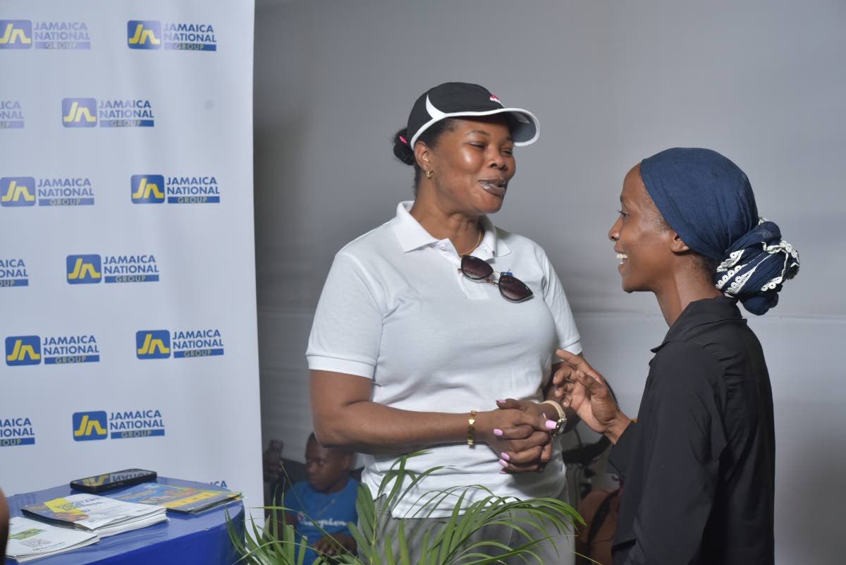 Ann-Marie Williams Swaby (left), client relations manager for JN Bank Small Business Loans, shares advice with a patron at the recent Denbigh Agricultural, Industrial and Food Show in Clarendon.